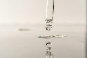 The texture of serum or oil with a pipette on a grey background. photo