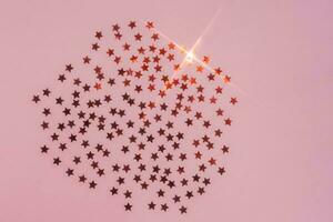 Abstract pink background with sparkles in the shape of stars. photo