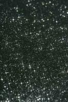 Abstract black background with sparkles in the shape of stars. photo