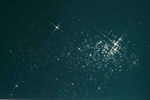 Abstract deep blue background with sparkles in the shape of stars. photo