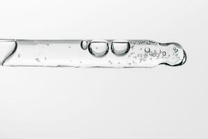 Transparent pipette with cosmetics on a white isolated background. photo