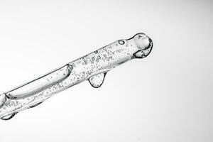 Transparent pipette with cosmetics on a light background. photo