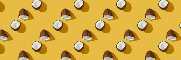 A pattern of coconuts on a bright yellow background. photo