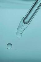 Pipette with cosmetic product in water with bubbles. photo