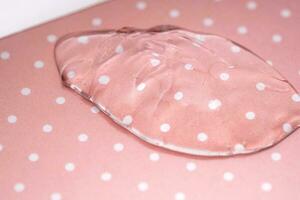 Transparent hyaluronic gel on a pink polka dots background. photo