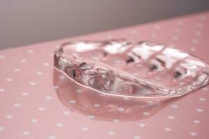 transparente hialurónico gel en un rosado polca puntos antecedentes. foto