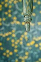 A dripping pipette with a drop of cosmetics gel. photo