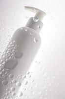 A bottle of shower gel, shampoo or body cream on the background of drops. photo