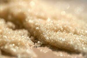 The texture of a yellow shining scrub on a beige background. photo