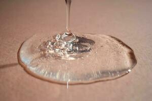 A drop of serum with bubbles on a beige background. photo