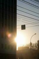 An urban landscape with a building, a road and a setting sun. photo