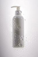 A bottle of shower gel, shampoo or body cream on the background of drops. photo