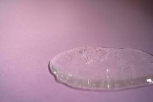 A drop of serum with bubbles on a beige background. photo