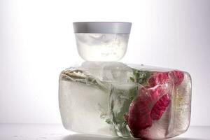 A jar of cosmetic gel on a background of ice with flowers. photo