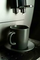 Café exprés es vertido dentro un Café exprés taza desde un hogar café máquina. foto