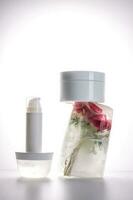 Gel and a jar of serum on a background of ice with flowers. photo