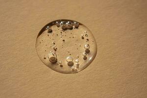 A drop of cosmetic gel on a beige background. photo