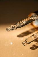 Three pipettes of cosmetic gel on a beige background. photo