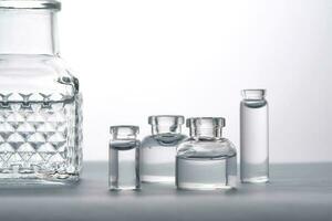 Different bottles of water on a light background. It can fit the theme of cosmetics, glass and freshness. photo