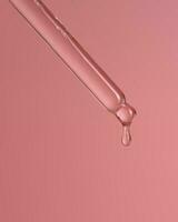 Dropper with serum or cosmetic oil on a pink background. photo