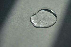 Pipette with spilled cosmetic oil or serum on a gray background. photo