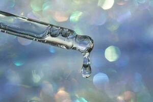 A pipette with a drop of serum in a Christmas theme . photo