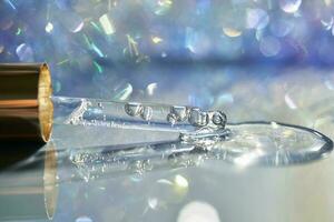 A pipette with a drop of serum in a Christmas theme . photo