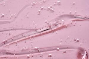 The texture of the cosmetic gel on a pink background. photo