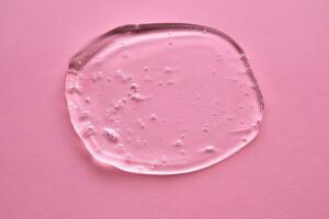 The texture of the cosmetic gel on a pink background. photo