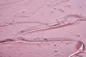 The texture of the cosmetic gel on a pink background. photo