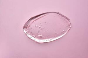 The texture of the cosmetic gel on a pink background. photo