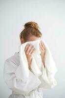 The girl wipes her face with a terry towel. photo