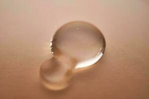 A juicy drop of gel on a beige background. photo