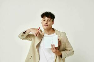 hermoso chico posando con un bloc en un traje ligero antecedentes inalterado foto