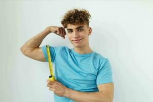 handsome guy yardstick in hand in blue t-shirts isolated background photo