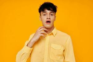 handsome man in yellow shirt posing emotions yellow background photo