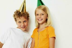 Boy and girl posing emotions holiday colorful caps isolated background unaltered photo