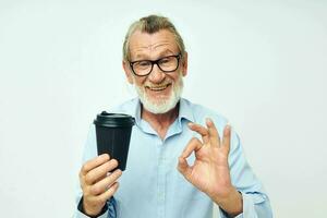 Senior grey-haired man with a black glass in his hands a drink isolated background photo