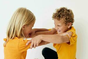 Cute preschool kids in yellow t-shirts standing side by side childhood emotions unaltered photo