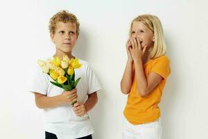 two joyful children with a bouquet of flowers gift birthday holiday childhood light background photo