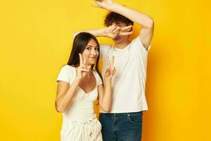 cute young couple standing side by side in white t-shirts posing Lifestyle unaltered photo