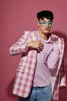 portrait of a young man fashionable glasses pink blazer posing studio pink background unaltered photo