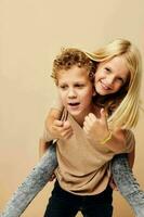 Little boy and girl in beige t-shirts posing for fun childhood unaltered photo