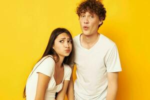 cute young couple standing side by side in white t-shirts posing Lifestyle unaltered photo