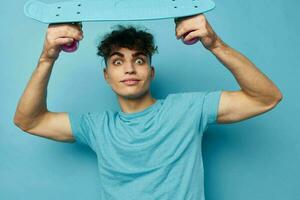 handsome young man skateboard in hand in blue t-shirts unaltered photo