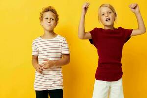cheerful children standing side by side posing childhood emotions yellow background photo