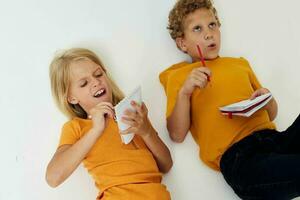 cheerful children lie on the floor with notepads and pencils childhood lifestyle unaltered photo