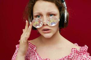 mujer en un rosado chaqueta con auriculares lentes en el formar de un diamante foto