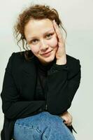 beautiful woman sitting on a chair in a black jacket fashion posing light background unaltered photo