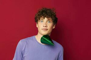 guy with curly hair green cap holiday red background photo